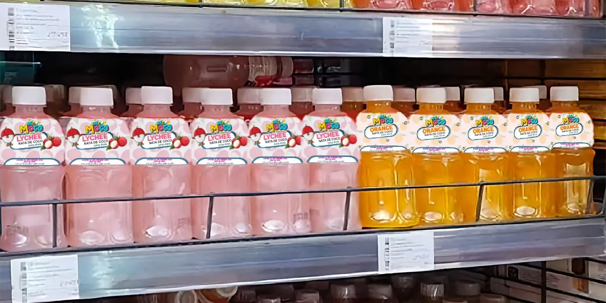 Shelves stocked with Mr. Moco Nata de Coco drinks in various flavors, including pineapple, pomegranate, lychee, orange, and peach.